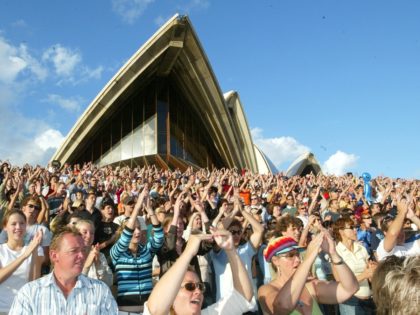 A crowd of more than 4,000 Australians at the Opera House in Sydney wave to TV cameras as