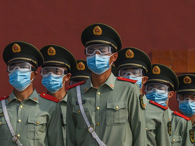 BEIJING, CHINA - MAY 02: Chinese paramilitary police wear protective masks as they guard the entrance to the Forbidden City as it re-opened to limited visitors for the May holiday, on May 2, 2020 in Beijing, China. Beijing lowered its risk level after more than three months Thursday in advance …