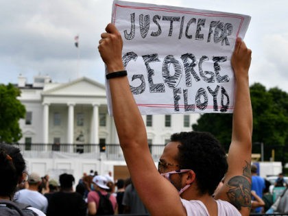 Protesters hold signs as they gather outside the White House in Washington, DC, on May 29, 2020 in a demonstration over the death of George Floyd, a black man who died after a white policeman kneeled on his neck for several minutes. - Demonstrations are being held across the US …
