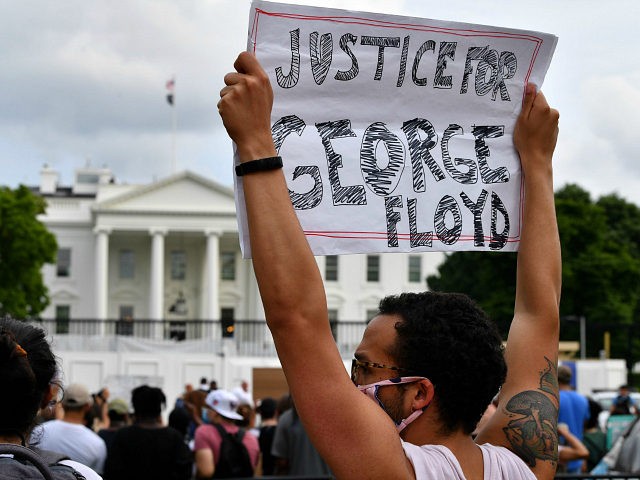 Protesters hold signs as they gather outside the White House in Washington, DC, on May 29,