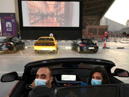 Passengers watch a movie from their car at a drive-in cinema outside the Mall of Emirates