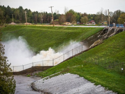Water rushes through the Edenville Dam, Tuesday, May 19, 2020 in Edenville, Mich. People living along two mid-Michigan lakes and parts of a river have been evacuated following several days of heavy rain that produced flooding and put pressure on dams in the area. (Katy Kildee/Midland Daily News via AP)