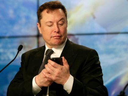 Elon Musk founder, CEO, and chief engineer/designer of SpaceX jokes with reporters as he pretends to be searching for an answer to a question on a cell phone during a news conference after a Falcon 9 SpaceX rocket test flight to demonstrate the capsule's emergency escape system at the Kennedy …