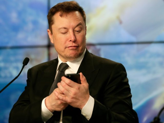 Elon Musk founder, CEO, and chief engineer/designer of SpaceX jokes with reporters as he p