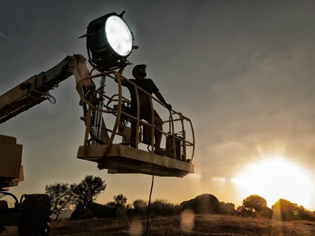 Lighting technician working on a shoot - stock photo