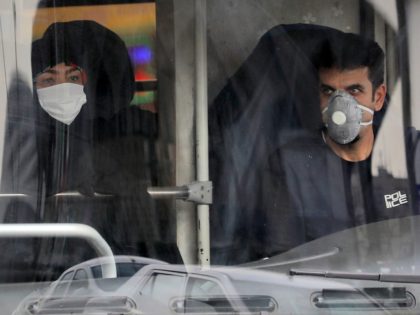 A public bus driver, right, and a commuter wear masks to help guard against the Coronavirus in downtown Tehran, Iran, Sunday, Feb. 23, 2020. On Sunday Iran's health ministry raised the death toll from the new virus to 8 people in the country, amid concerns that clusters there, as well …