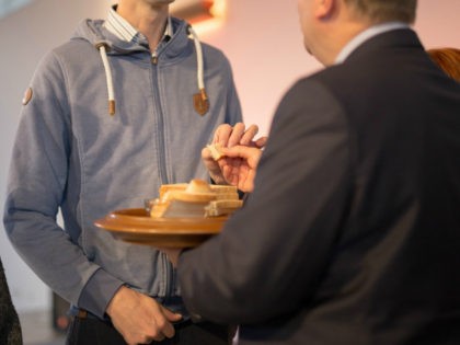Minister administers communion to man.
