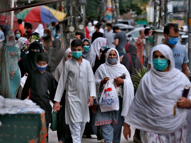 People wearing protective masks visit a market after the government relaxed the weeks-long lockdown that was enforced to curb the spread of the coronavirus, in Rawalpindi, Pakistan, Tuesday, May 12, 2020. (AP Photo/Anjum Naveed)