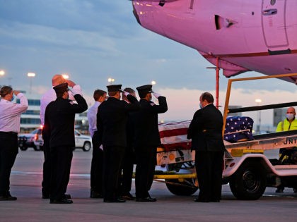 Ambulnz paramedics and Aurora firefighters salute as the casket carrying the body of paramedic Paul Cary is removed from a plane at Denver International Airport on Sunday, May 3, 2020, in Denver. Cary died from coronavirus after volunteering to help combat the pandemic in New York City. (Helen H. Richardson/The …