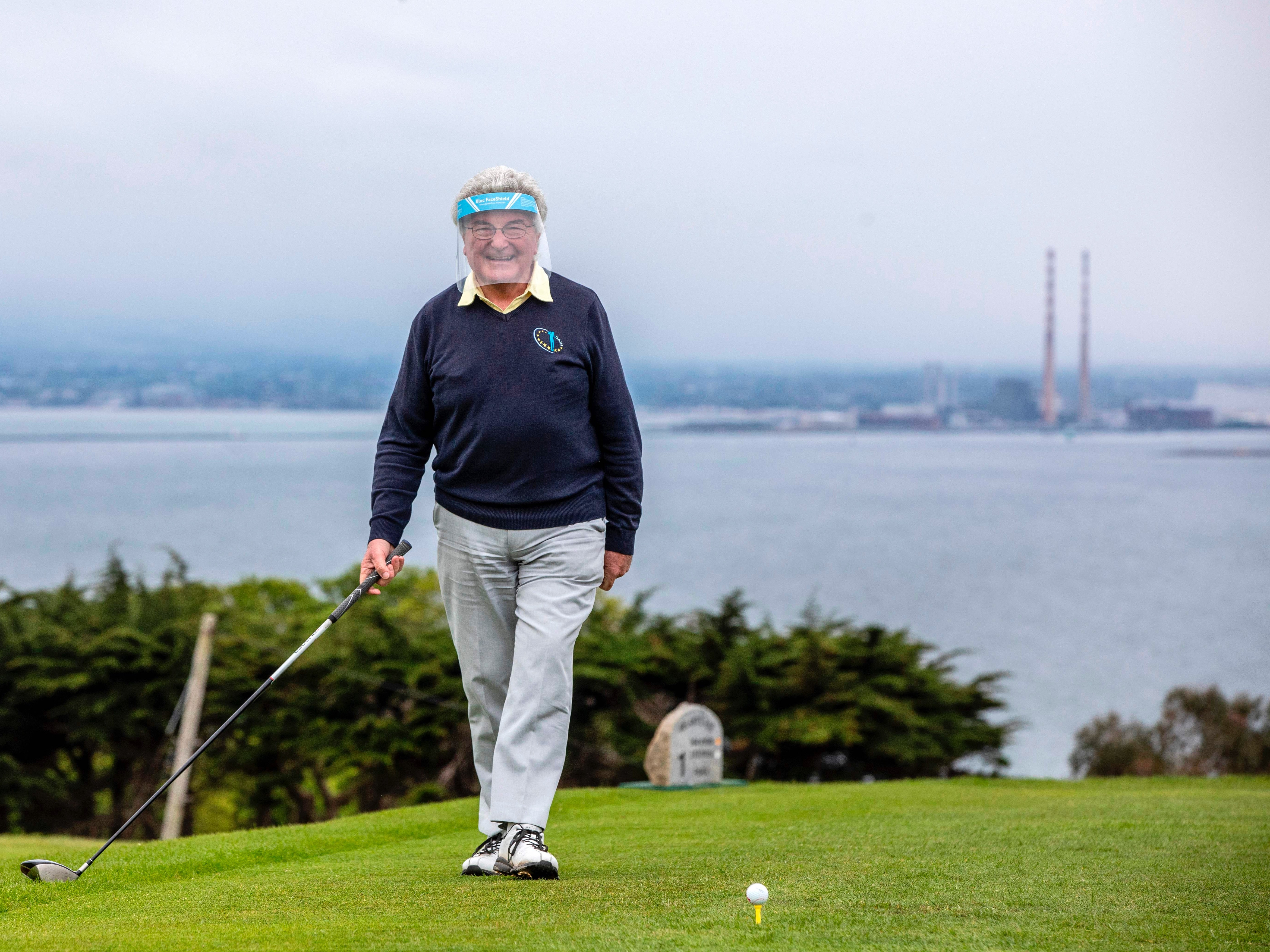 Michael O'Hanlon, wearing a protective visor, smiles as he prepares to play from the first tee at Howth Golf Club in Dublin on May 18, 2020, as golf courses reopen and Ireland cautiously begins to lift it's coronavirus lockdown. - Ireland launched the first tentative step in its plan to lift coronavirus lockdown on Monday, with staff returning to outdoor workplaces as some shops resumed trade and sports facilities unlocked their doors. (Photo by PAUL FAITH / AFP) (Photo by PAUL FAITH/AFP via Getty Images)