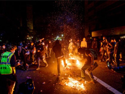 Demonstrators burn garbage in Oakland, Calif., on Friday, May 29, 2020, while protesting t