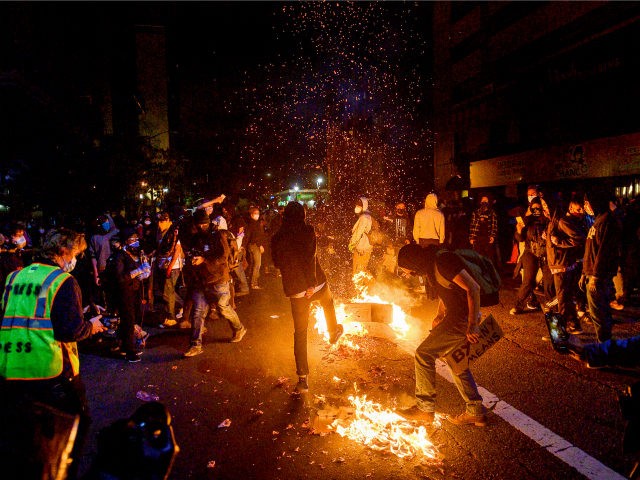 Demonstrators burn garbage in Oakland, Calif., on Friday, May 29, 2020, while protesting the Monday death of George Floyd, a handcuffed black man in police custody in Minneapolis. (AP Photo/Noah Berger)