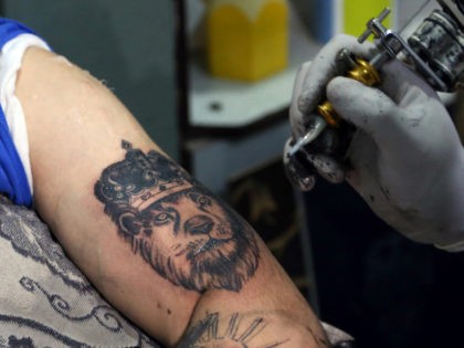 In this Wednesday, Nov. 20, 2019, photo, Omid Noori, 23, left, gets a lion tattoo on his left arm by Nazeer Mosawi, a tattoo artist in Kabul, Afghanistan. Mosawi, 42, fought for seven years in Afghanistan’s civil war with the Islamic insurgents. He says he is still fighting the war, …