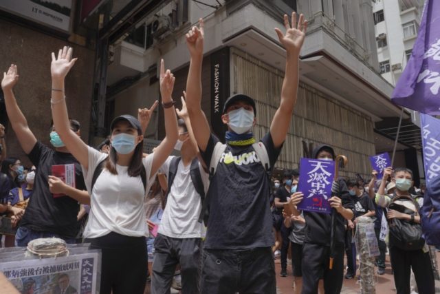 Protesters gesture with five fingers, signifying the "Five demands - not one less" as they march along a downtown street during a pro-democracy protest against Beijing's national security legislation in Hong Kong, Sunday, May 24, 2020. Hong Kong's pro-democracy camp has sharply criticised China's move to enact national security legislation …