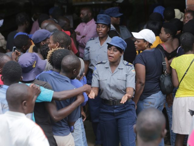Zimbabwean police control a crowd that had gathered to buy maize meal at a supermarket in Harare, Zimbabwe, Wednesday, March 25, 2020. Zimbabwe's public hospital doctors went on strike Wednesday over what they called a lack of adequate protective gear as the coronavirus begins to spread in a country whose …