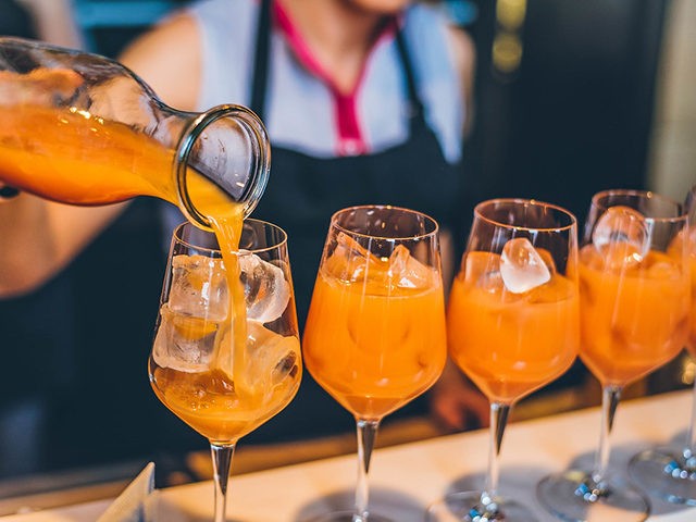 Bartender preparing Cocktails with Mango, Orange and Ice