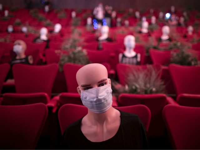 Mannequins wearing face masks are placed to provide social distancing in a theatre in Madr