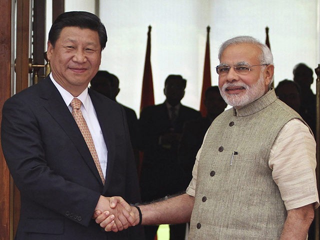 In this Wednesday, Sept. 17, 2014 file photo, Indian Prime Minister Narendra Modi, right, shakes hand with Chinese President Xi Jinping as he welcomes him at a hotel in Ahmadabad, India. Modi is travelling April 27-28, 2018 to meet with Xi for a visit that some experts have described as …