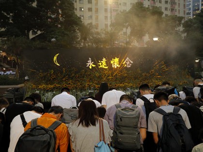 Attendees take part in a public memorial for Marco Leung, the 35-year-old man who fell to