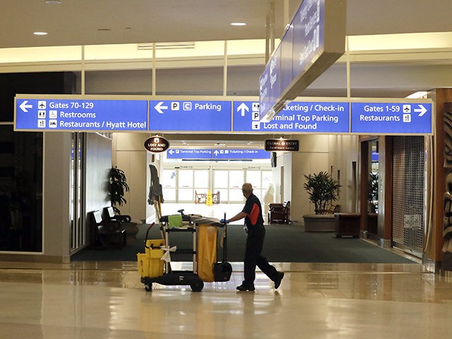 An airport employees pushes a cleaning cart through the terminal at Orlando International