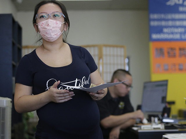 Employee Cynthia Bao, who is pregnant wears a protective mask to avoid getting sick, as sh