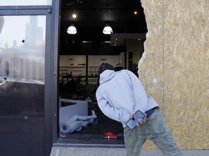 A man looks into a burglarized and ransacked business Tuesday, June 2, 2020, in St. Louis. People were seen removing merchandise from the business on Monday night well after peaceful protesters gathered in the afternoon to speak out against the death of George Floyd who died after being restrained by …