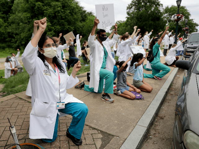 Healthcare professionals gather outside Barnes-Jewish Hospital to demonstrate in support of the Black Lives Matter movement Friday, June 5, 2020, in St. Louis, Mo. The White Coats for Black Lives protest was organized to stand in solidarity with those speaking out against the death of George Floyd who died after …