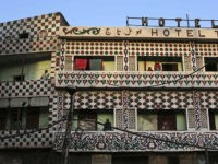 Indians stand outside their rooms at a hotel in New Delhi, India, early Wednesday, Sept. 26, 2012. (AP Photo/Kevin Frayer)
