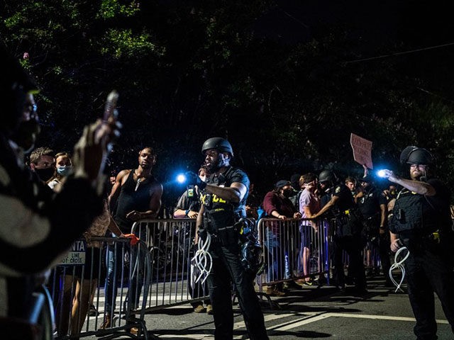 Police flash a light on the protestors during a protest to mark Juneteenth in Atlanta, Geo