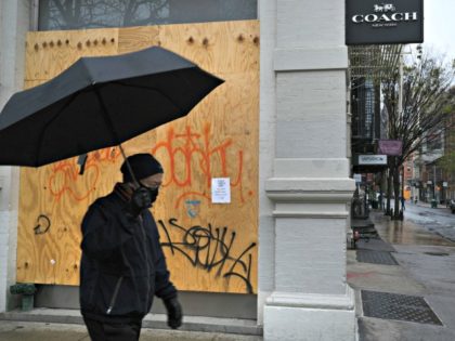 NEW YORK, NY - APRIL 26: A person walks past a boarded-up business in the popular Manhatta