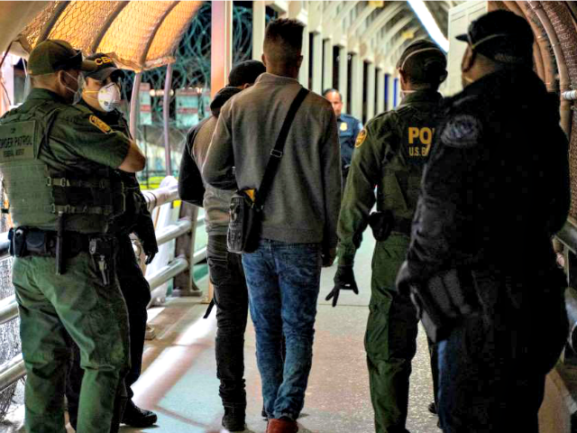 U.S. Border Patrol and Customs and Border Protection agents escort asylum applicants across the Paso del Norte International Bridge between Ciudad Juárez, Mexico, and El Paso.