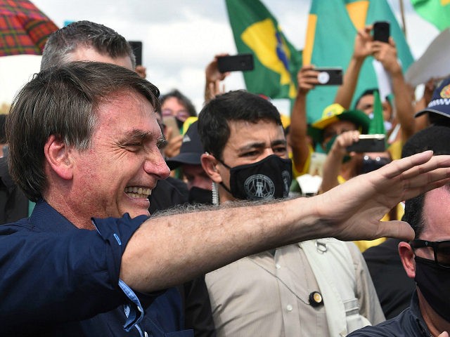 Brazil's President Jair Bolsonaro greets supporters upon arrival at Planalto Palace in Bra