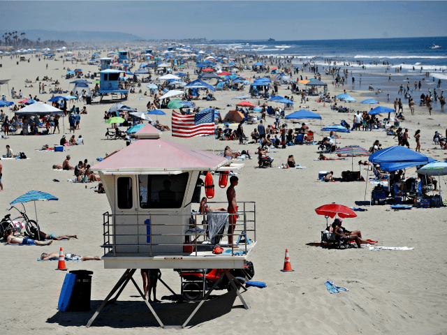 In this June 27, 2020, file photo, a lifeguard keeps watch over a packed beach in Huntington Beach, Calif. The Los Angeles County Department of Public Health is ordering L.A. County beaches closed from July 3 through July 6 at 5:00 a.m. to prevent dangerous crowding that results in the …