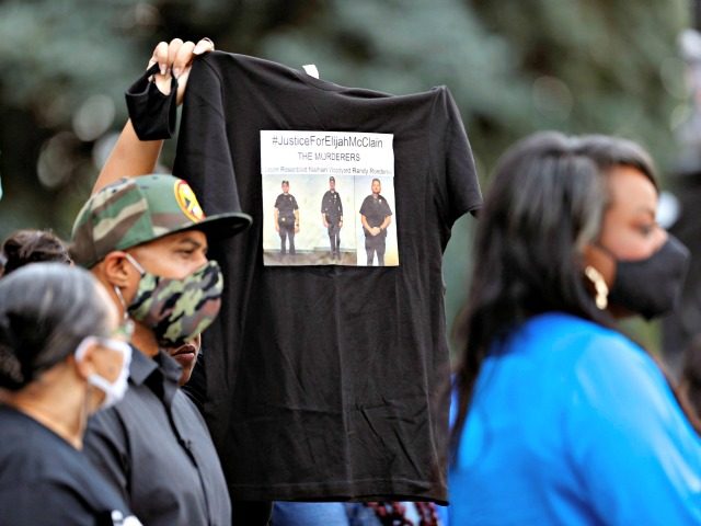 A supporter holds up a shirt to call attention to the death of Elijah McClain (Photo: AP P