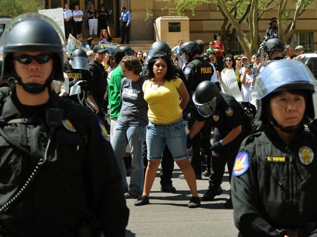 Anti-SB1070 protesters are arrested after staging a sit-in and blocking 1st Avenue in downtown Phoenix on July 29, 2010. Protestors and police in riot gear clashed in several downtown locations with demonstrations against a new Arizona immigration law just hours after it went into effect. Demonstrators angrily denounced the law, …