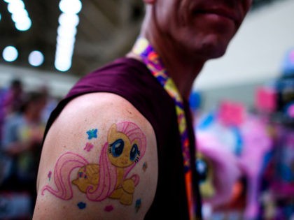 A man shows off his tatoo during the BronyCon convention, a gathering for "My Little Pony" fans, at the Baltimore Convention centre in Baltimore, Maryland on August 1, 2019. - BronyCon is an annual fan convention held for fans of "My Little Pony: Friendship Is Magic," among them adult and …