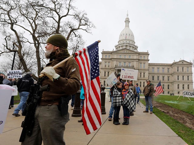 People take part in a protest for "Michiganders Against Excessive Quarantine" at the Michigan State Capitol in Lansing, Michigan on April 15, 2020. - The group is upset with Michigan Governor Gretchen Whitmer's(D-MI) expanded the states stay-at-home order to contain the spread of the coronavirus. (Photo by JEFF KOWALSKY / …