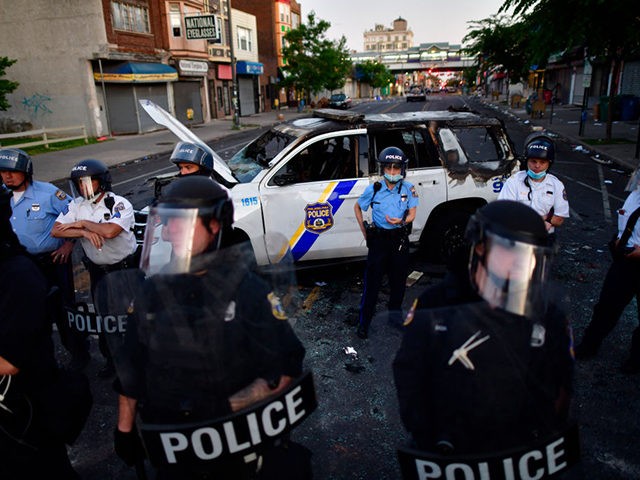 PHILADELPHIA, PA - MAY 31: Police create a barrier in front of a damaged police vehicle du
