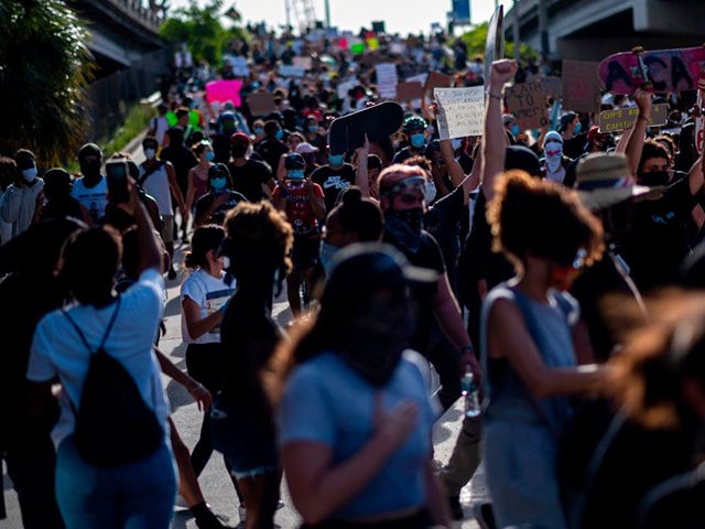 Protesters march during a rally in response to the recent death of George Floyd, an unarmed black man who died while in police custody in Minneapolis, in Miami, Florida on May 31, 2020. - Thousands of National Guard troops patrolled major US cities after five consecutive nights of protests over …