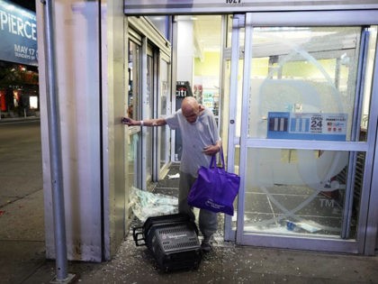 A man walks out of a looted Walgreens in Times Square shortly before the 11 p.m. curfew we