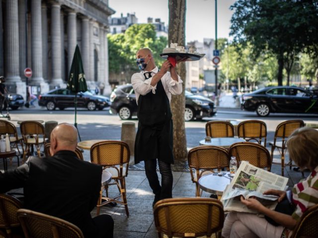 A waiter works at the terrasse of a restaurant in Paris on June 2, 2020, as cafes and restaurants reopen in France, while the country eases lockdown measures taken to curb the spread of the COVID-19 (the novel coronavirus). (Photo by Martin BUREAU / AFP) (Photo by MARTIN BUREAU/AFP via …