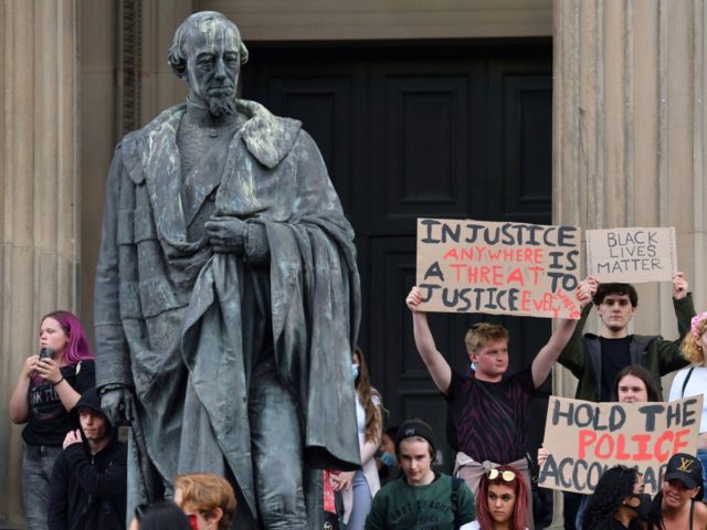 Protesters hold placards next to the statue of 19th century British Prime Minister Benjamin Disraeli outside St George's Hall in Liverpool, northwest England, on June 2, 2020, during demonstration after George Floyd, an unarmed black man who died after a police officer knelt on his neck during an arrest in …
