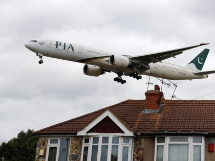 A Pakistan International Airlines Boeing 777 comes in over houses, to land at Heathrow airport in west London as the UK government's planned 14-day quarantine for international arrivals to limit the spread of Covid-19 starts on June 8, 2020. (Photo by Adrian DENNIS / AFP) (Photo by ADRIAN DENNIS/AFP via …