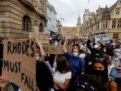 Protestors hold placards during a protest called by the Rhodes Must Fall campaign calling for the removal of the statue of British imperialist Cecil John Rhodes outside Oriel College, at the University of Oxford on June 9, 2020. - Following the toppling of slave trader Edward Colston during a Black …