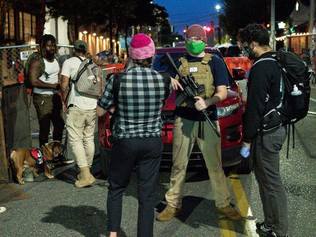 SEATTLE, WA - JUNE 10: A volunteer holds a firearm while working security at an entrance t