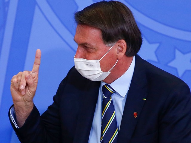 Brazilian President Jair Bolsonaro gestures as he wears a facemask during an official ceremony at the presidential office in Brasilia, on June 17, 2020. (Photo by Sergio LIMA / AFP) (Photo by SERGIO LIMA/AFP via Getty Images)