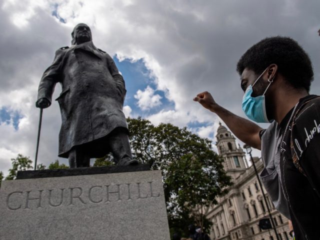 LONDON, ENGLAND - 20 JUNE: A protester raises his fist next to a statue of Winston Churchill in Parliament Square during a Black Lives Matter demonstration on June 20, 2020 in London, United Kingdom. Black Lives Matter protests are continuing across the UK following the death of African American George …