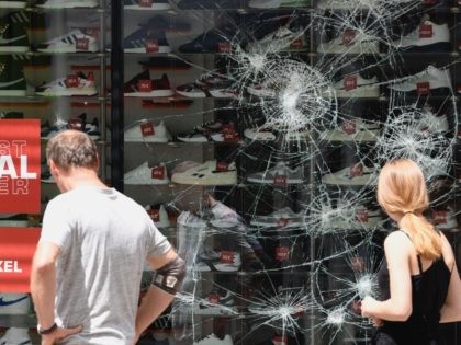 People look on a destroyed shop window of a shoe store in Stuttgart, southern Germany on J