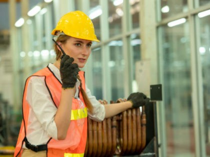 Engineer woman using radio communication at factory.