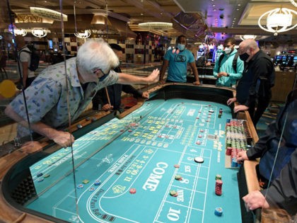 LAS VEGAS, NEVADA - JUNE 04: Guests play craps on a table with plexiglass safety shields a